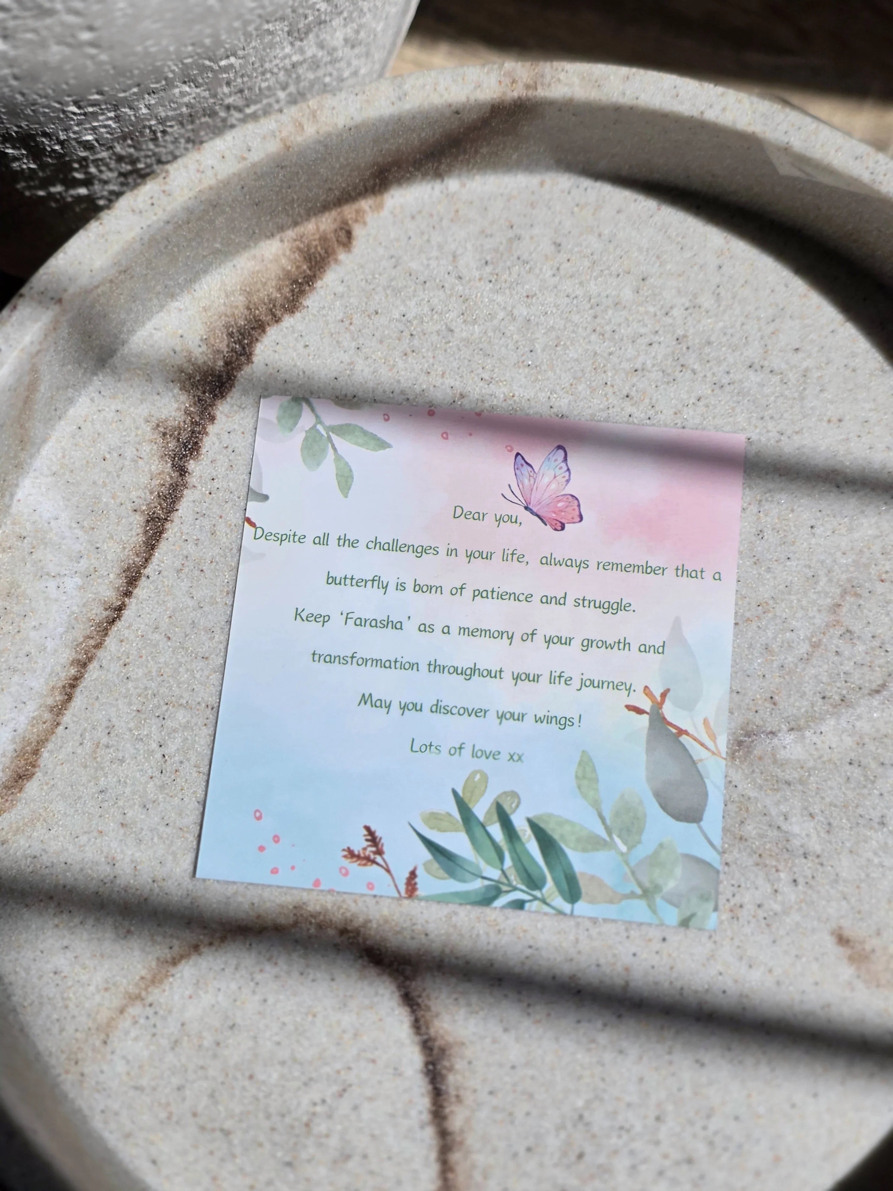 Card with butterfly illustration and text on a textured surface
