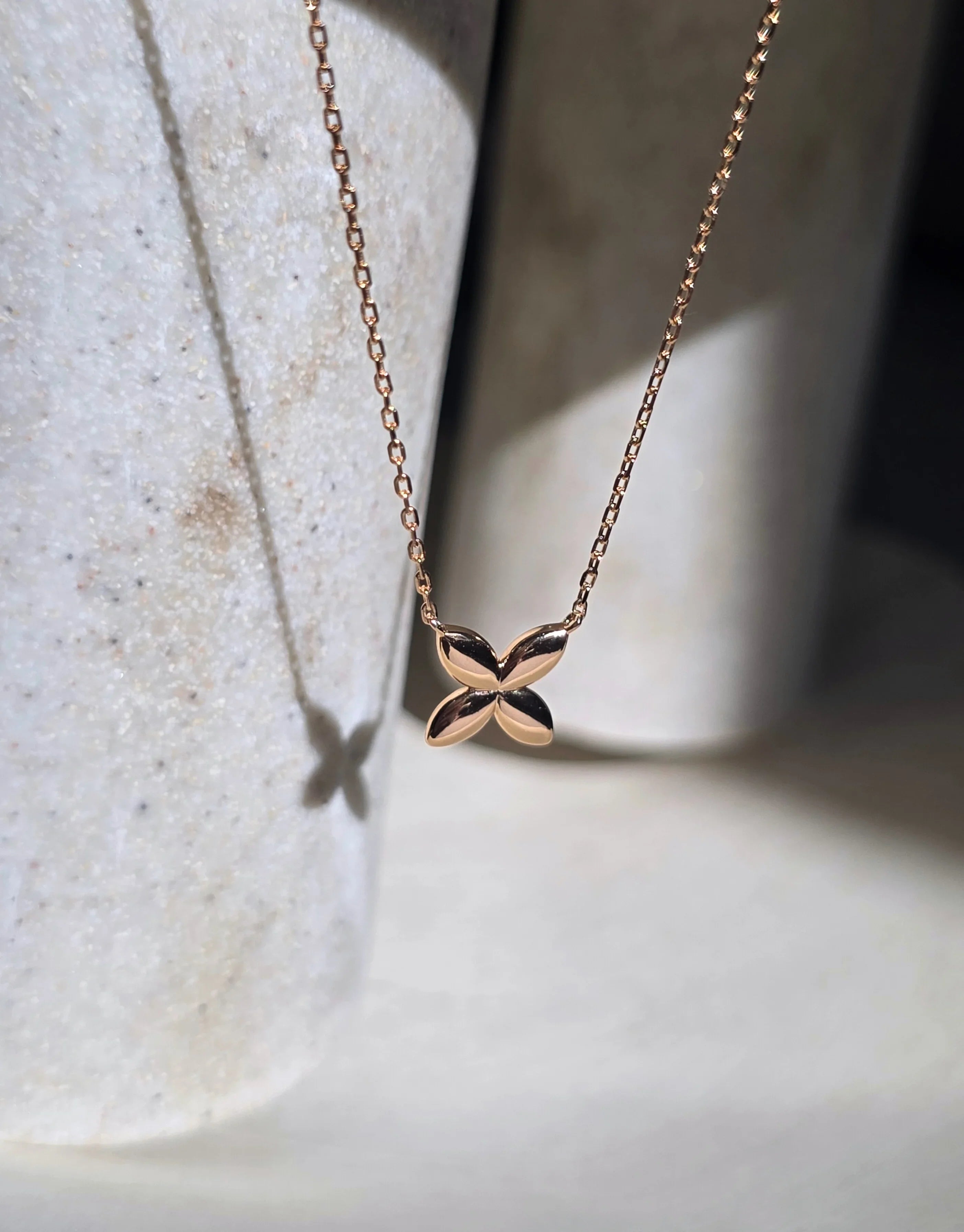 Rose gold butterfly necklace on a light background- front