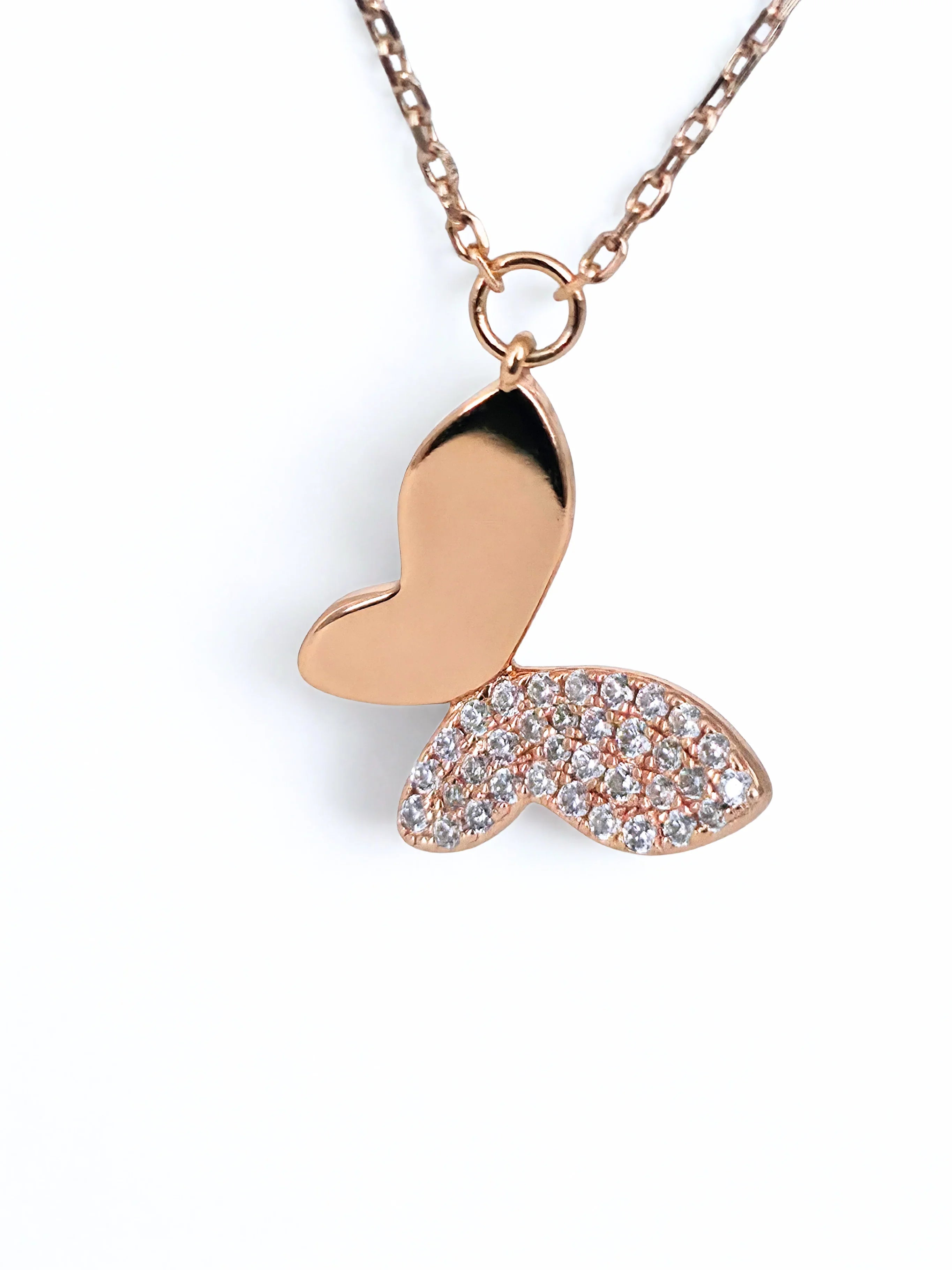 Rose gold butterfly pendant necklace on a white background- chic butterfly necklace far shot