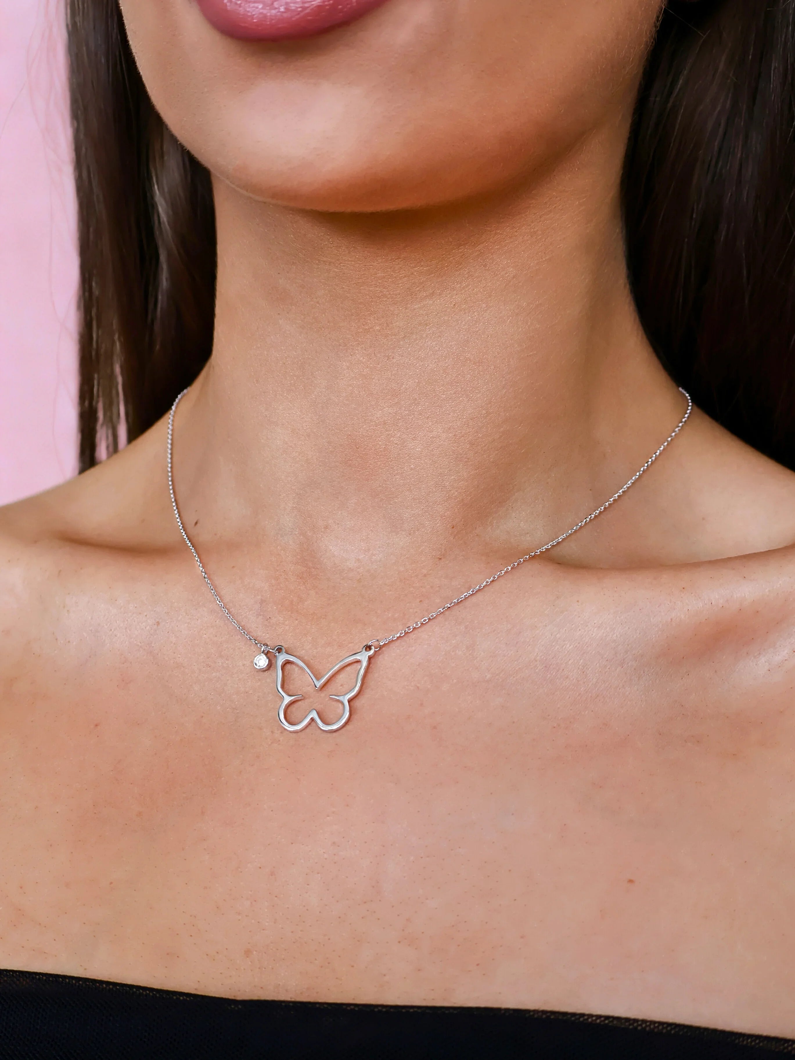 Silver butterfly pendant necklace with a small clear gemstone charm on a fine chain, minimalist jewellery
