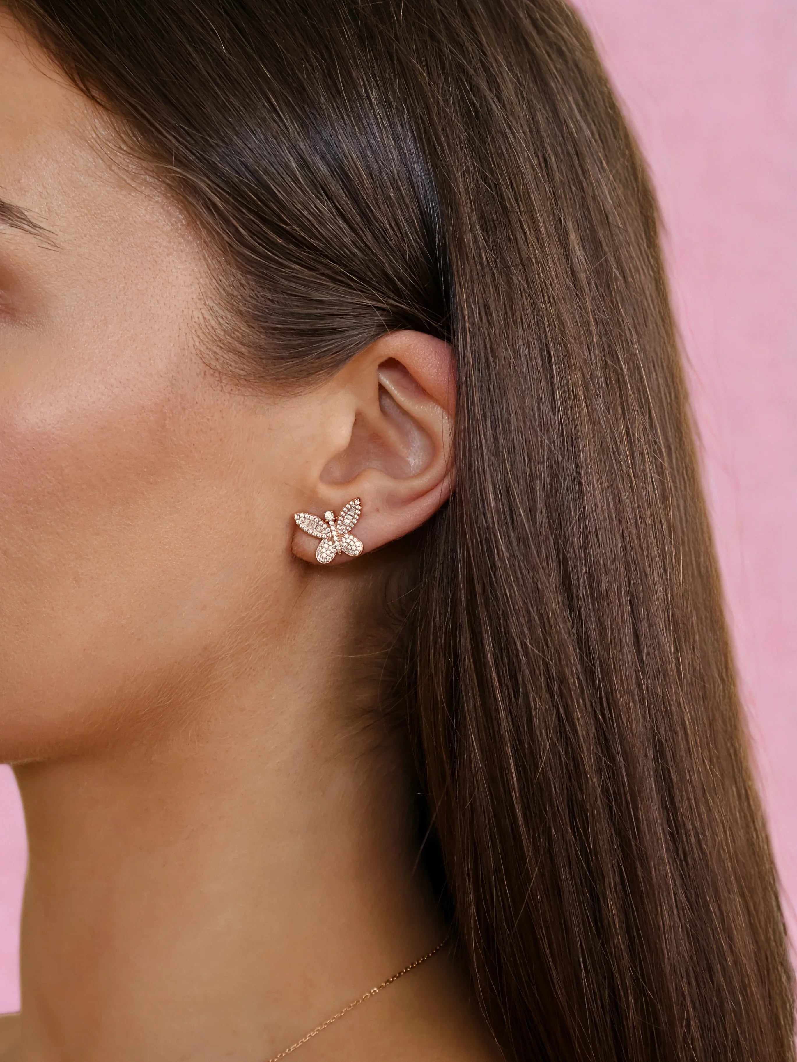 Rose gold butterfly-shaped pendant adorned with sparkling clear crystals and baguette stones