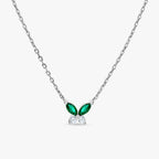 Silver chain necklace with butterfly-shaped pendant featuring green emerald and clear diamond stones
