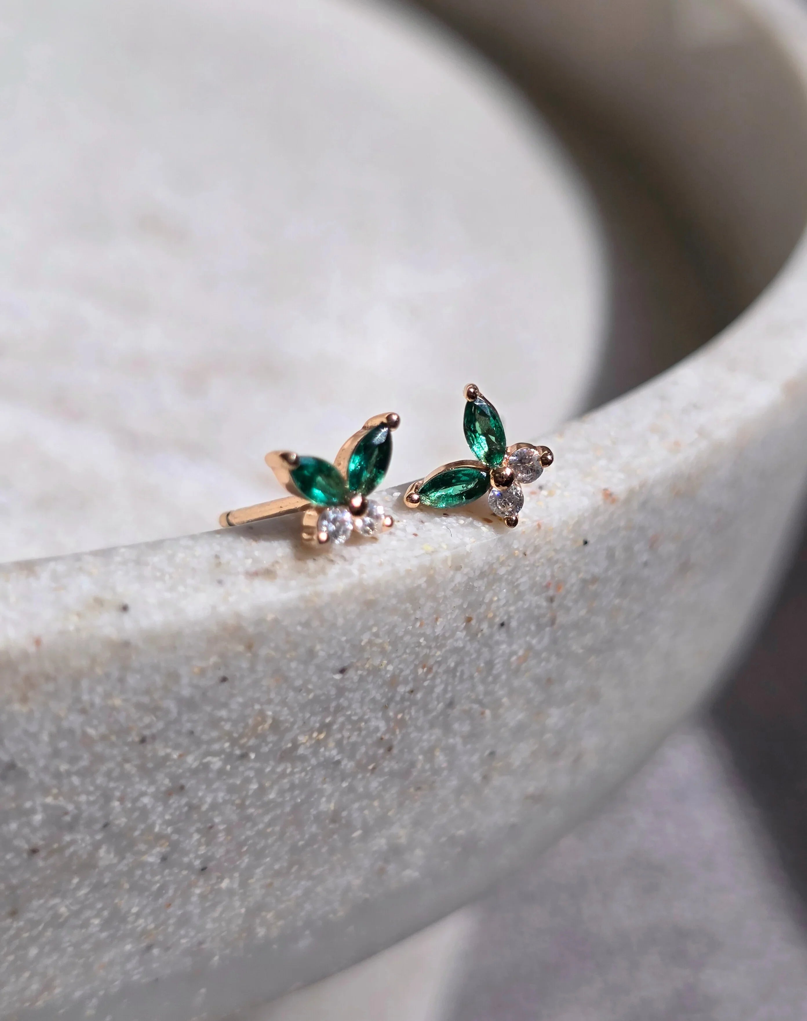 Pair of green gemstone earrings on a light stone surface- a paire