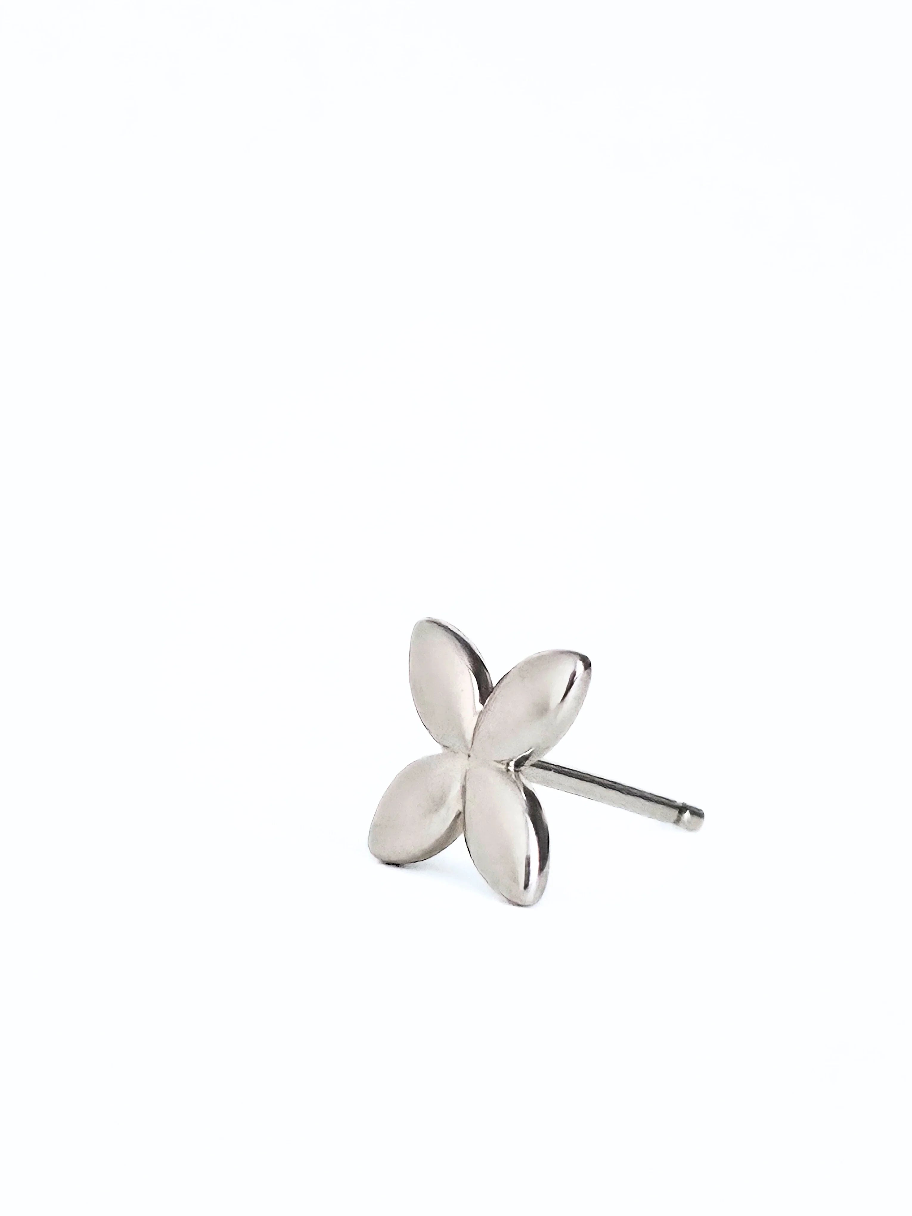 Silver flower-shaped earring on a white background- front