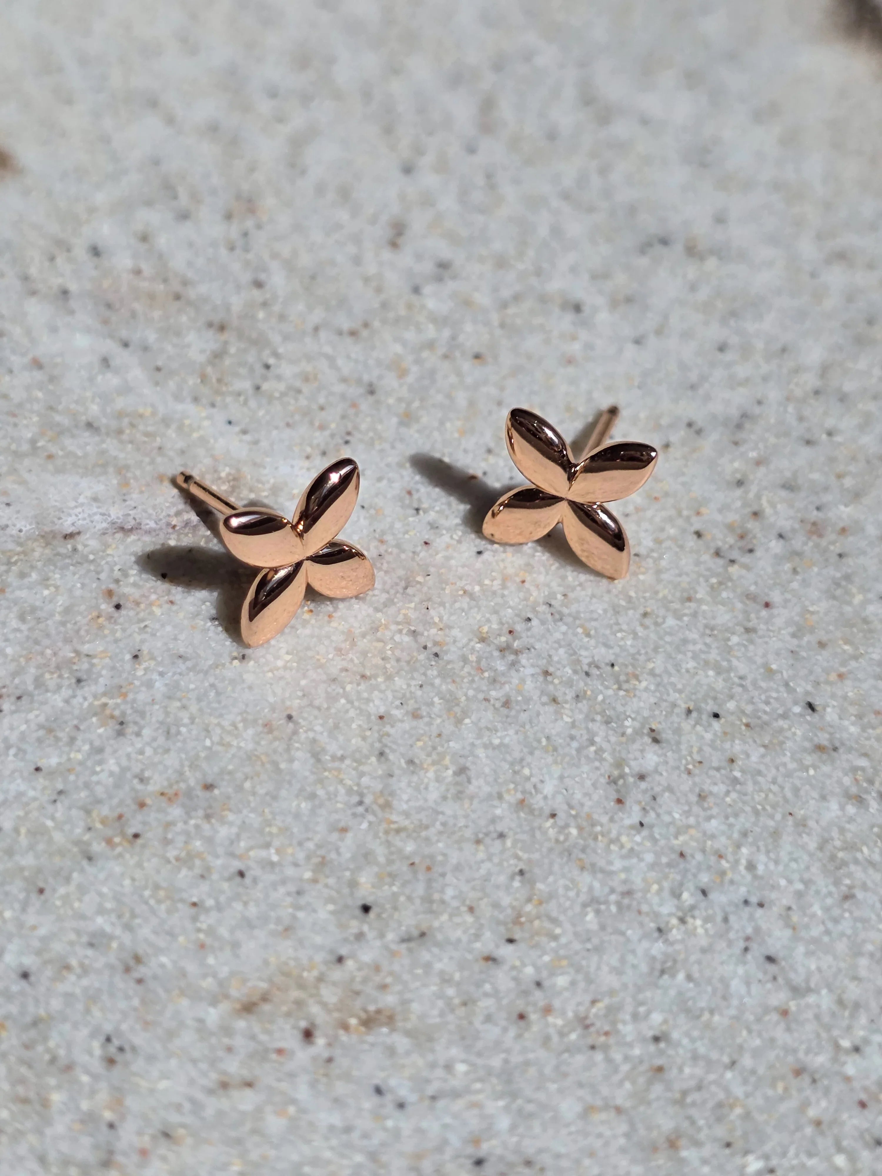 Rose gold butterfly earrings on a light gray surface- pair