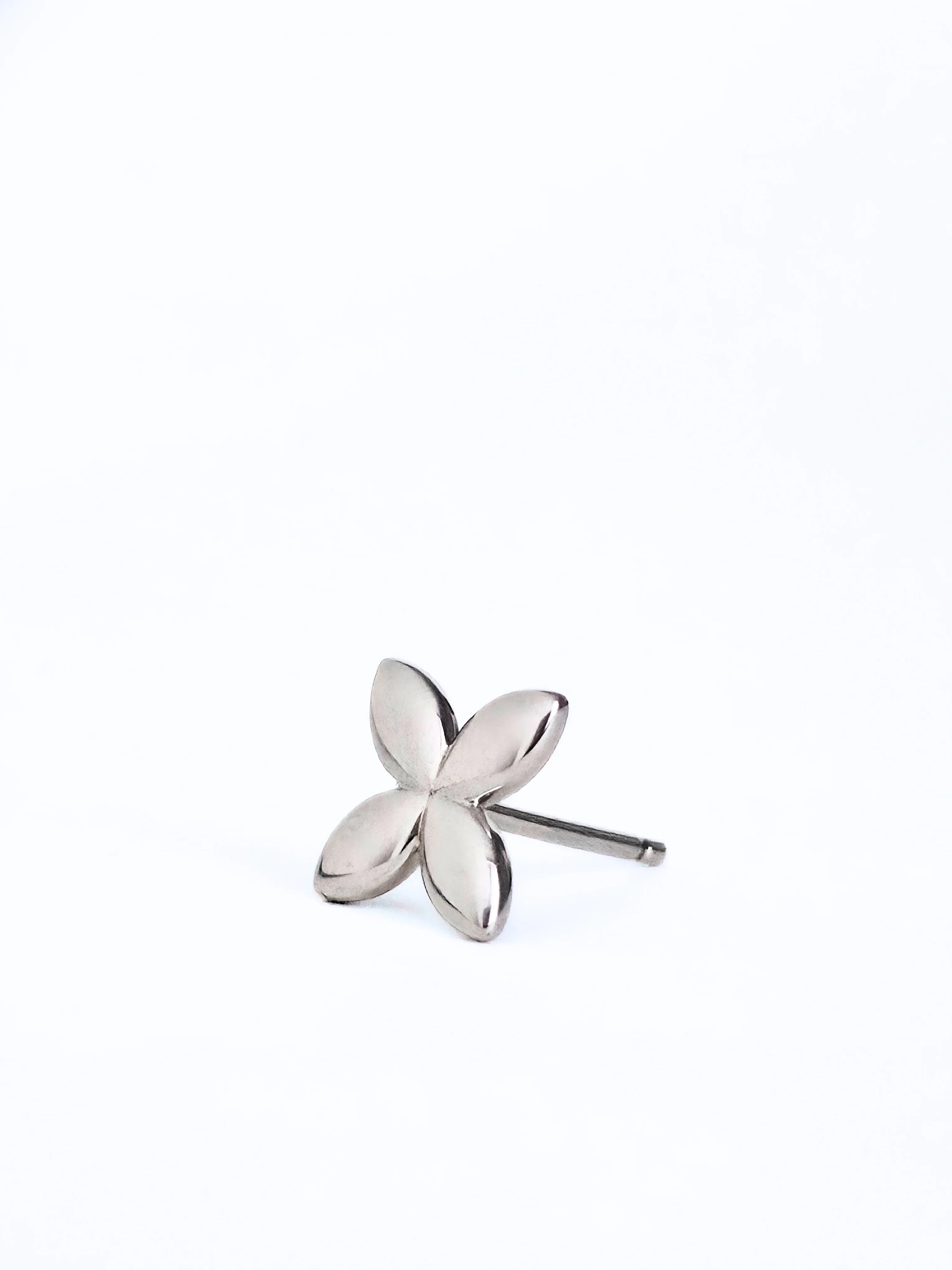 Silver flower-shaped earring on a white background- front