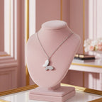 Silver butterfly necklace with one wing encrusted in crystals on pink velvet jewelry display