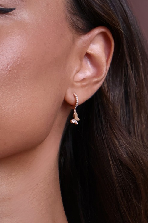 Close-up of a person wearing a delicate earring with a blurred background