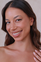 Woman with a warm smile against a neutral background