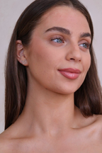 Woman with long brown hair and a neutral background