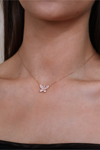 Rose gold butterfly necklace on a person's neck
