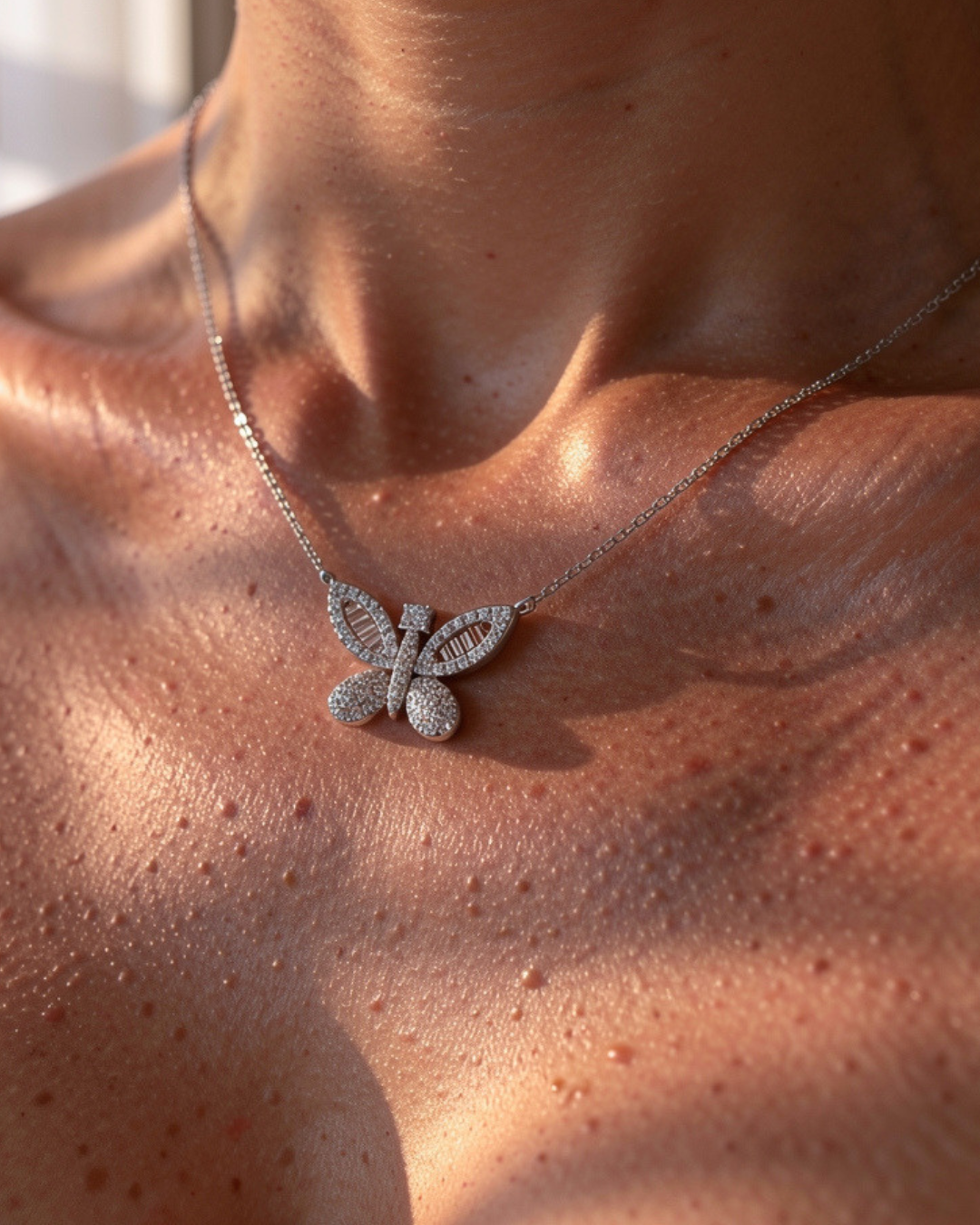 Butterfly-shaped necklace on a person's neck with a close-up focus.