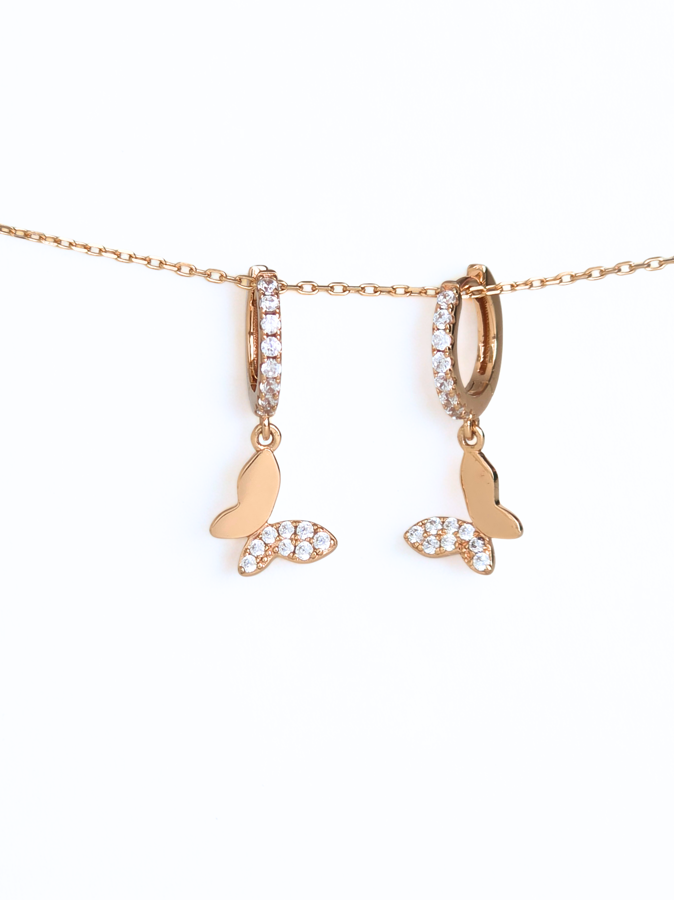 Rose gold necklace with a butterfly pendant on a white background- butterfly huggies - rose gold