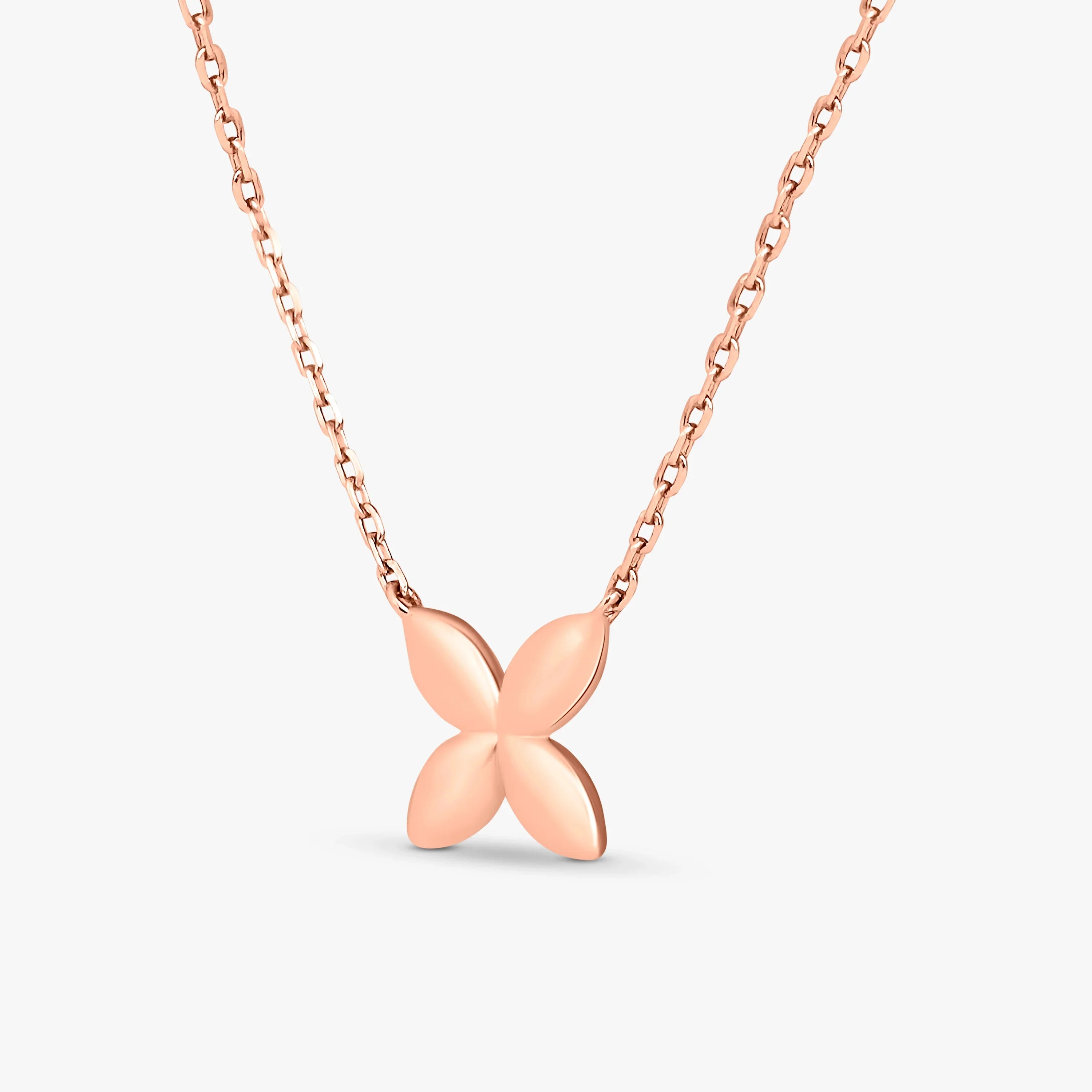 Rose gold necklace with a smooth four-petal flower pendant on a chain against white background