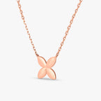 Rose gold necklace with a smooth four-petal flower pendant on a chain against white background