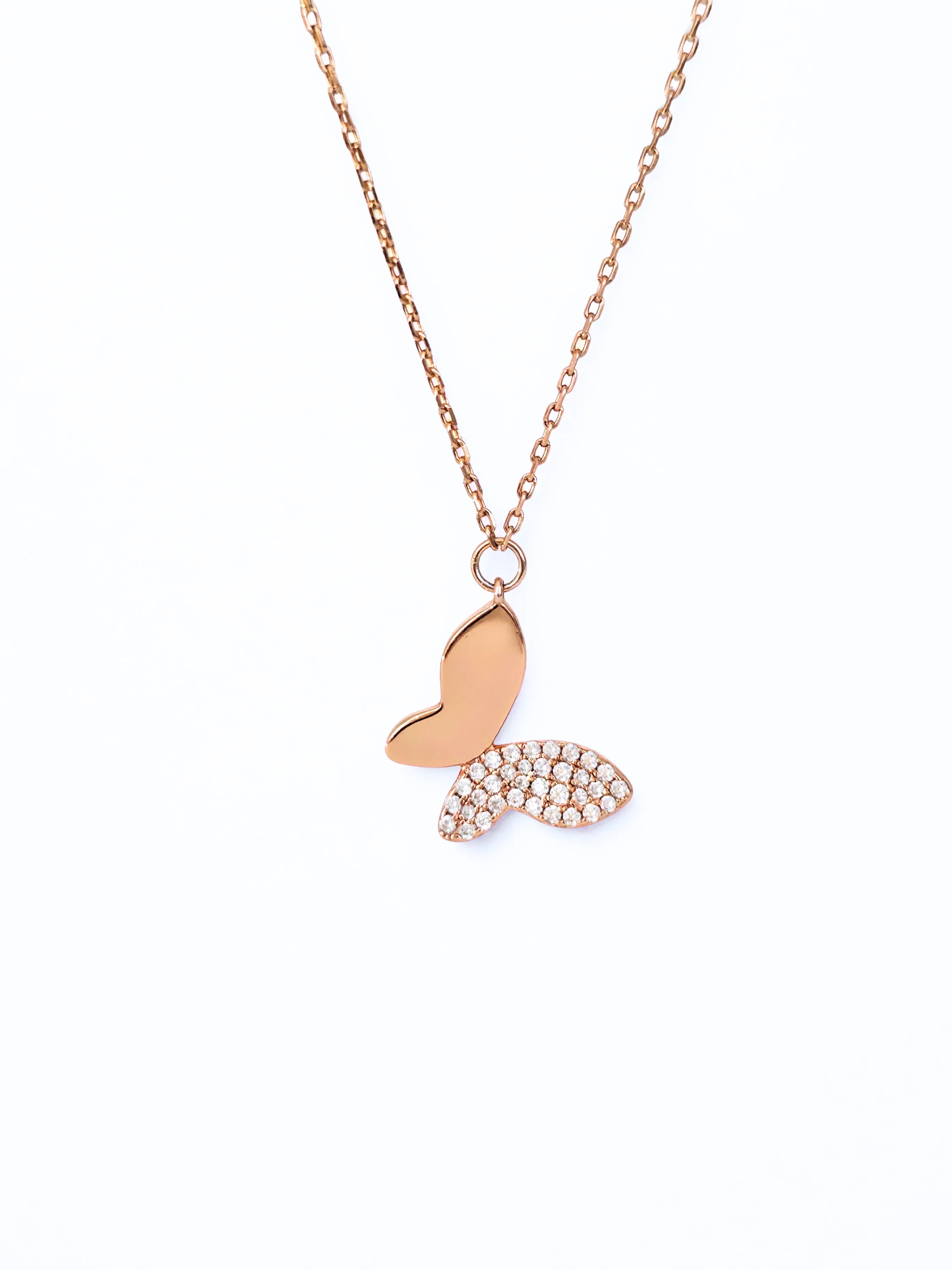 Rose gold butterfly pendant necklace on a white background- chic butterfly necklace far shot