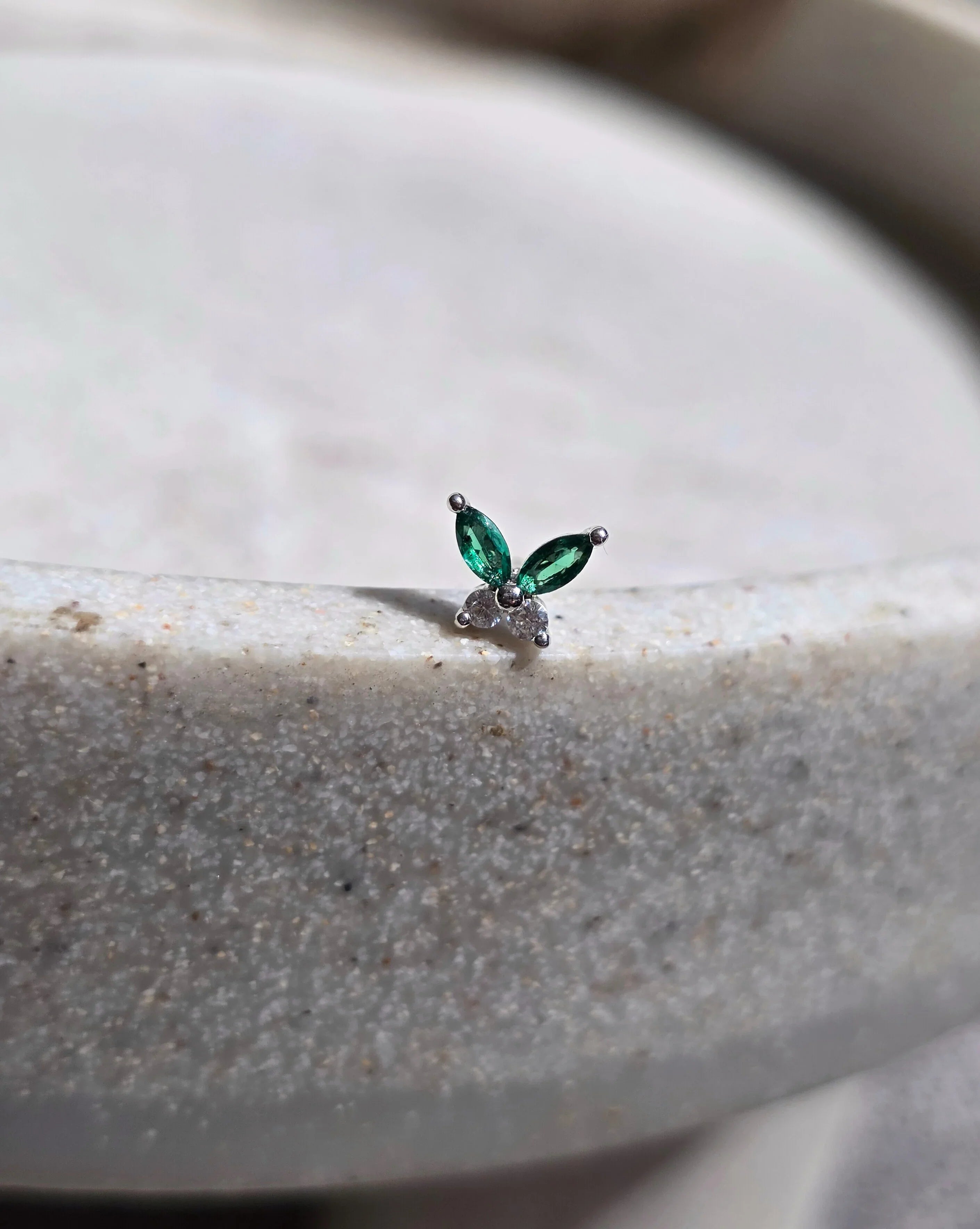 Small green earring on a textured surface- straight